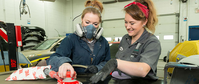 an Automotive Refinishing Technician journeyperson supervising an apprentice that is using a sander on a vehicle.