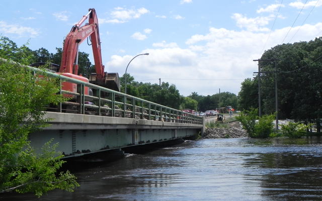 Manitoba Infrastructure and Transportation crews drop rock into the Souris River on the Hwy 22 bridge crossing to protect the bridge pillars.