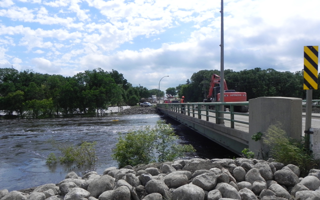 Manitoba Infrastructure and Transportation crews drop rock into the Souris River on the Hwy 22 bridge crossing to protect the bridge pillars.