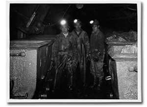 Photo of three men in a mine.