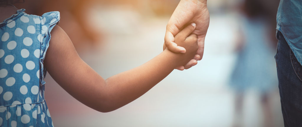 Close-up image of child and parent holding hands - Family Law Manitoba website banner
