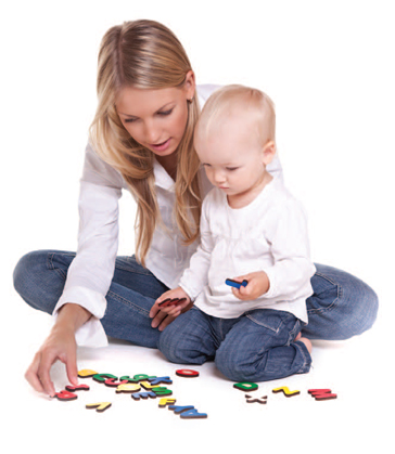 woman and girl playing with letters on the floor