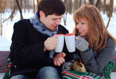 man and woman holding mugs and smiling