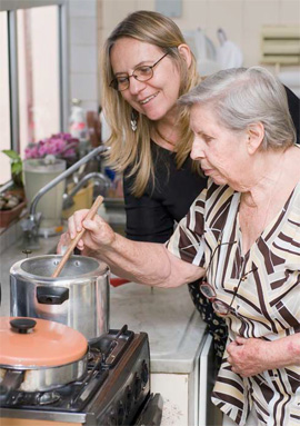woman stirring a pot on the stove while a woman watches