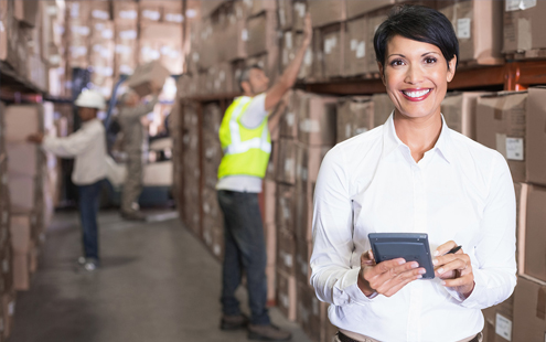 Image of a woman holding a device in a warehouse