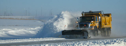 Truck plowing snow off highway